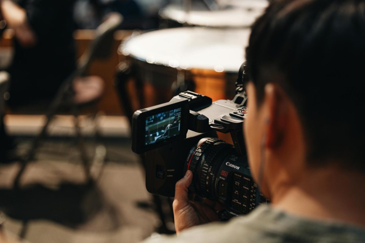 https://www.pexels.com/photo/filmmaker-using-canon-camera-in-studio-29060670/